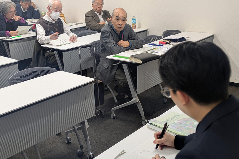 労働経済白書の説明会で参加者の質問を聞く木村室長補佐（右側）